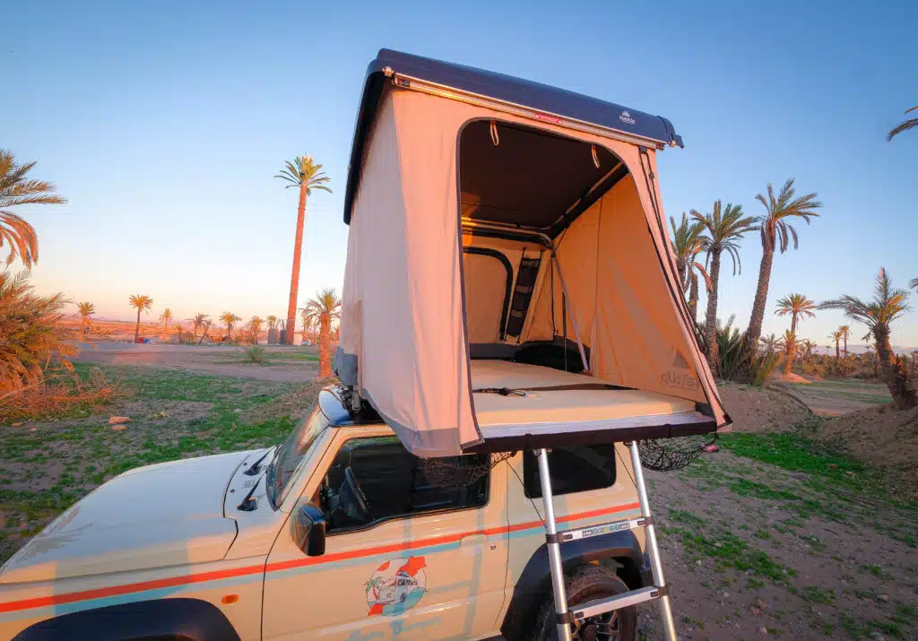Tente de toit ouverte du Suzuki Jimny 4x4 camper Baba Camper au coucher de soleil à Marrakech